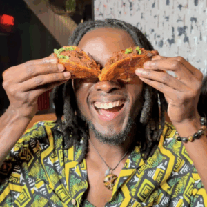 a man holding tacos up to his eyes