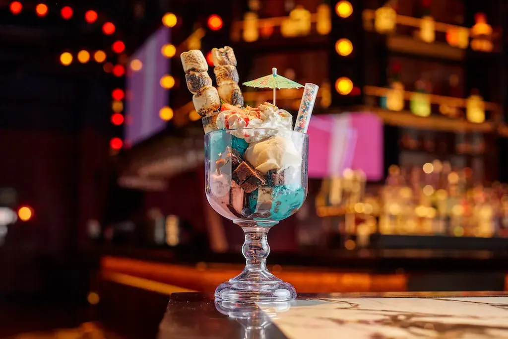 A specialty dessert with marshmallows and a cocktail umbrella